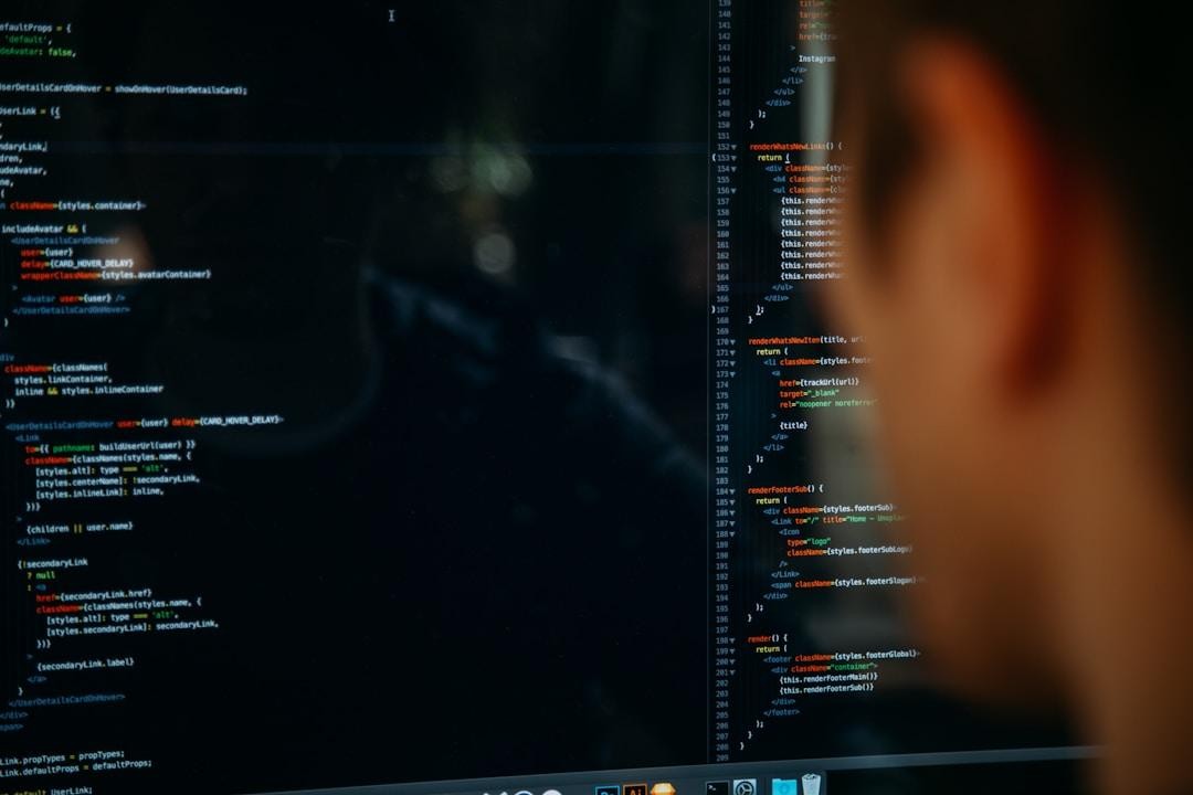A person focused on a computer screen displaying code, symbolizing AI automation for enhanced operational efficiency
